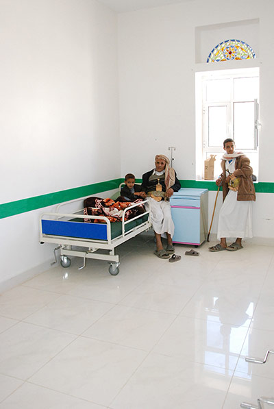 Ali Abdulla waits with his four-year-old son Ahmad, who is recovering from pneumonia