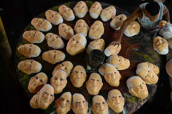 24 hours: Niteroi, Brazil: A woman paints masks of Pope Francis in a factory