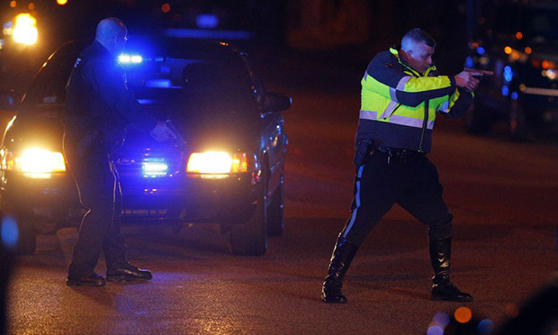 A police officer keeps a man on the ground in Watertown, west of Boston