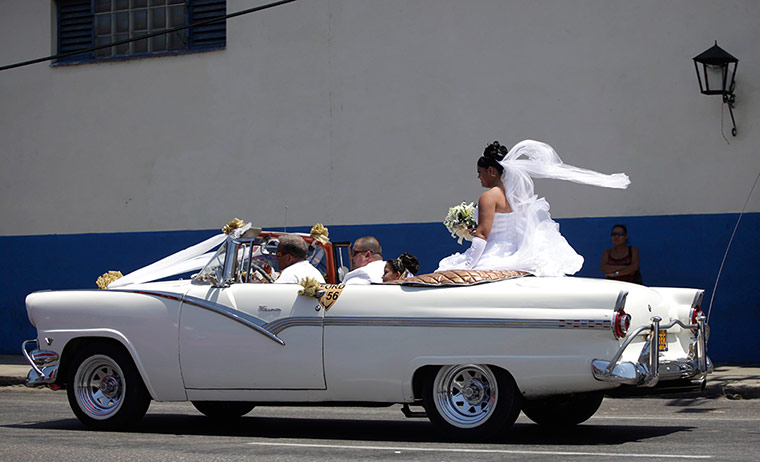 24 hours in pictures: A bride rides on the back of convertible car