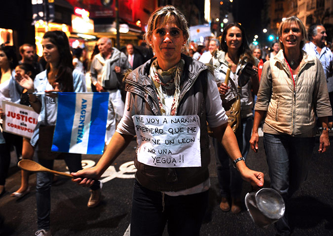 24 hours in pictures: A woman holds an empty pan during a protest
