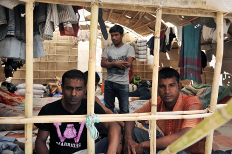 Migrant workers sit inside a makeshift camp in Nea Manolada on April 18, 2013.