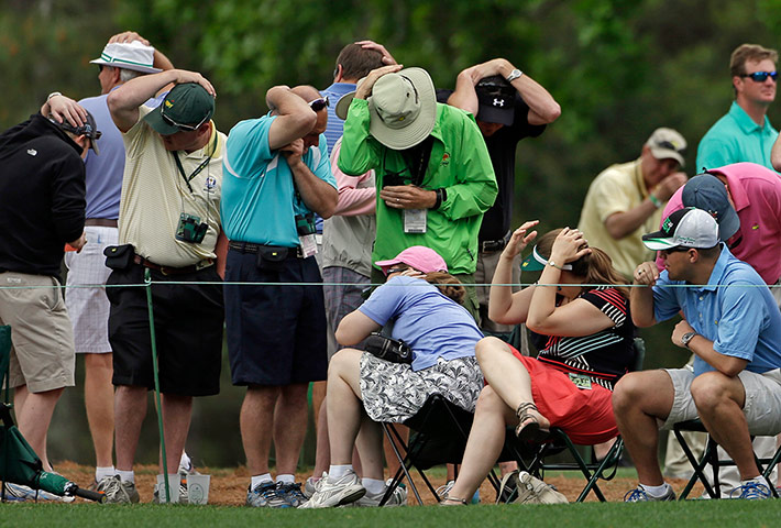 Best of sport 19/04/2013: Spectators cover their heads at the Masters