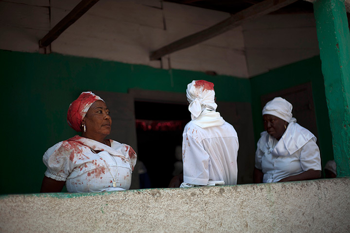24 hours in pictures: Souvenance, Haiti: Voodoo believers wearing white clothing stained with blo