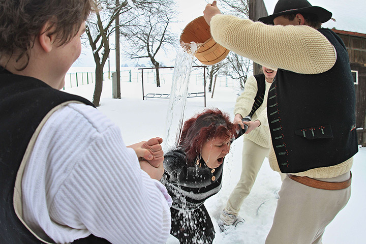 24 hours in pictures: Jablunkov, Czech Republic: A men in traditional costume pours water on a wo