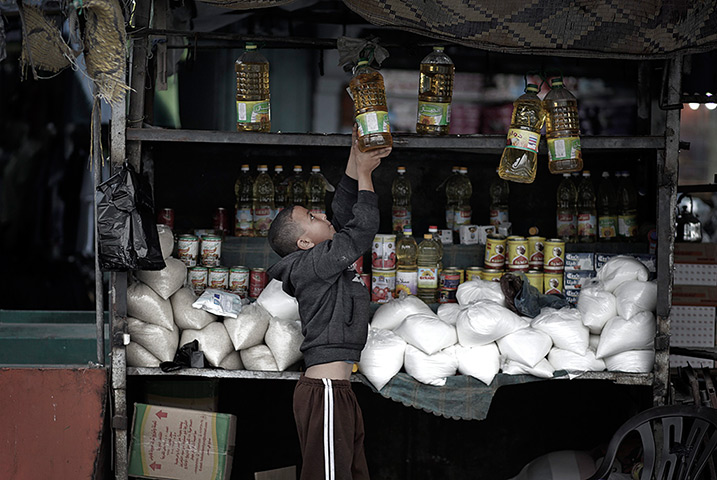 24 hours in pictures: Gaza Strip, Gaza: A Palestinian child works of a food stall in a traditiona