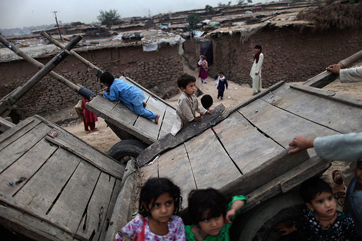 24 Hours: Afghan refugee children play on wooden carts in Islamabad, Pakistan