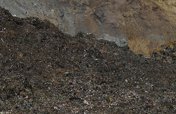 24 Hours: A worker (C) walks on a collapsed dumpsi