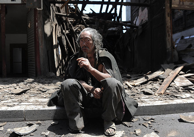 24 Hours: A man sits in front of houses destroyed by an earthquake in Sichuan, China
