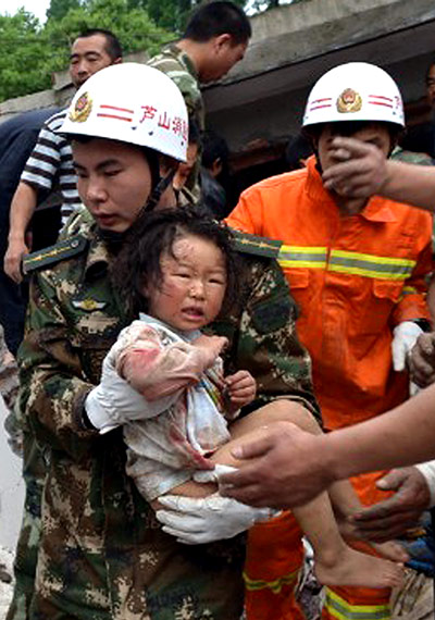 China: A rescuer carries a child to safety afte