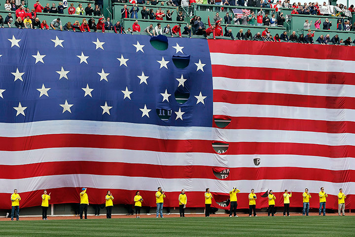24 hours: Boston Marathon volunteers stand beneath a giant flag on the outfield wall 