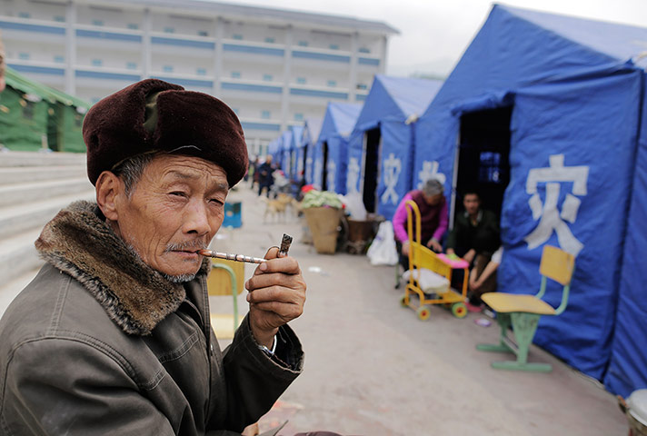 Dan Chung in China: An elderly man smokes a pipe at a temporary campsite in Longmen.