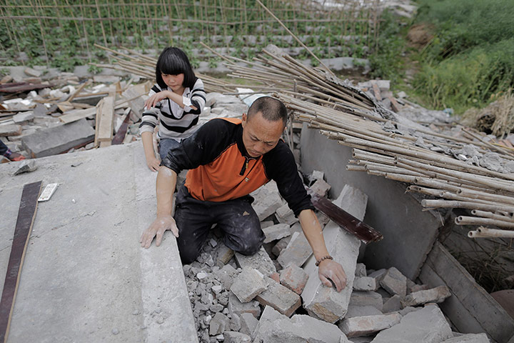 Dan Chung in China: Zhang Yichuan and her father clamber over the ruins of their house to searc