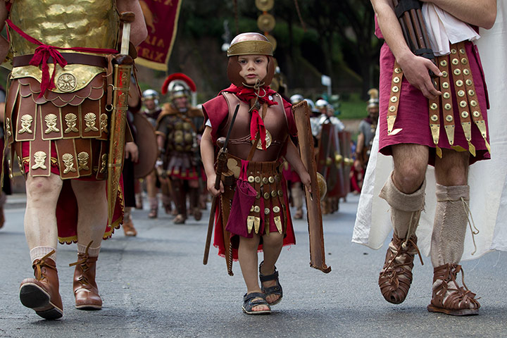 The birth of Rome: Ancient Roman costumed people parade in the ancient areas of Colosseum, Cir