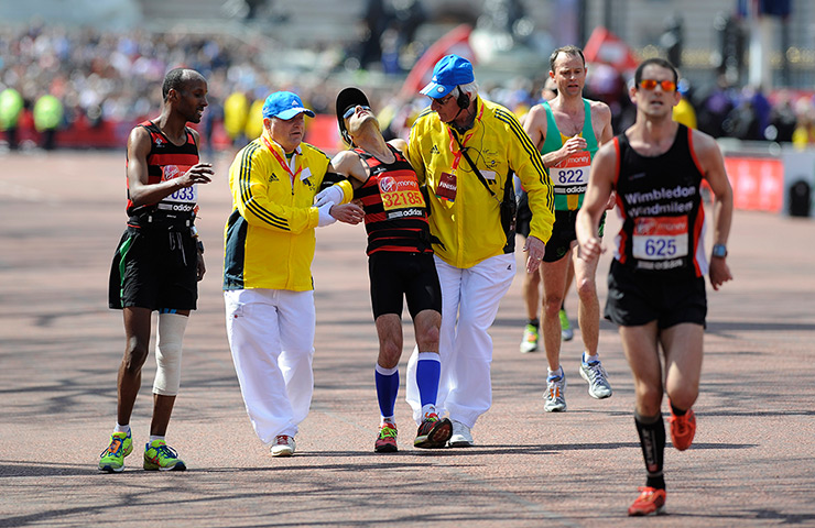 London Marathon: A collapsing runner is helped towards the finishing line on The Mall