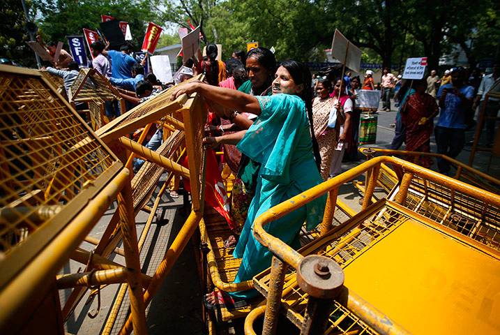 24 hours in pictures (2): Indian women bring down a barricade during a protest
