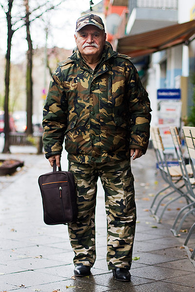big picture - what ali : man in camouflage suit with hat and holding a bag