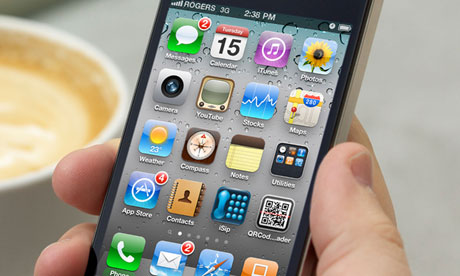 Man hand holding an iPhone 4 showing the application screen at a cafe