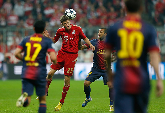 Bayern versus Barca 2: Bayern's Thomas Muller heads the ball pressed by Barcelona's Daniel Alves