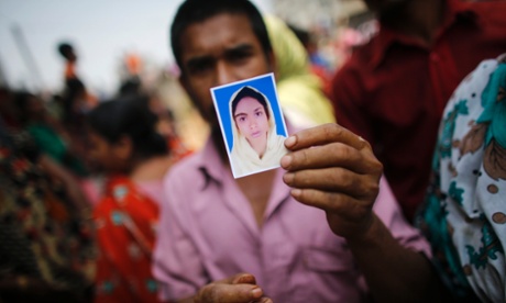 A relative holds a picture of a missing worker, who was working in the Rana Plaza building when it collapsed, in Savar.