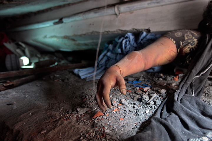 24 hours in pictures: Savar, Bangladesh: A victim's body is trapped in rubble after a garment fac