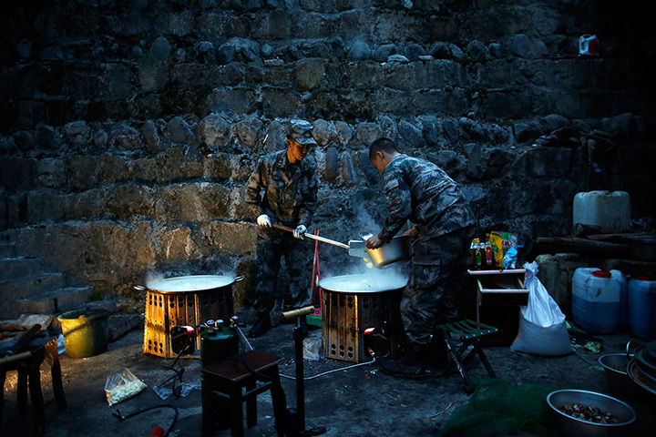 24 hours in pictures: Sichuan China: Chinese soldiers cook breakfast in a rescue camp in Taiping 