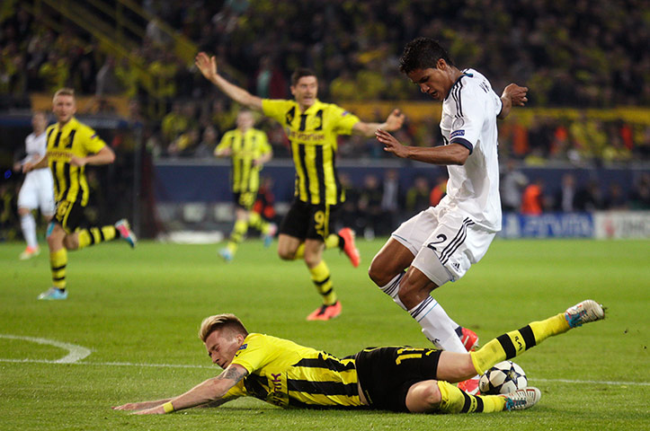 Dort v Real: Marco Reus goes down under the challenge from Raphael Varane 