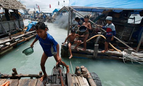 A child walks at a floating mine site off Bangka Island