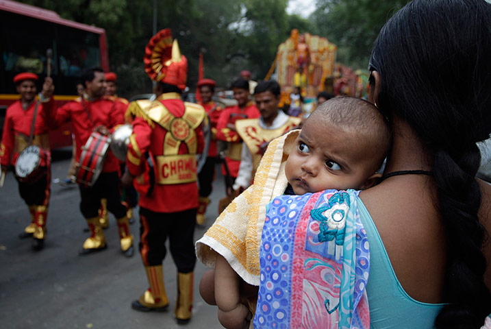 24 hours: New Delhi, India: An Indian woman holds her child as she watches