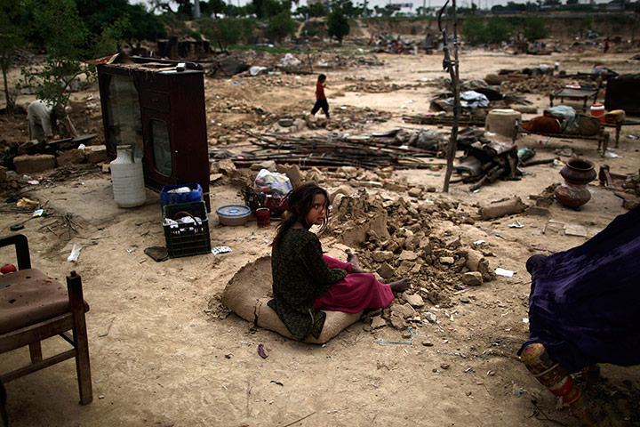 20 Photos: A Pakistani girl sits amongst the rubble of her makeshift home 
