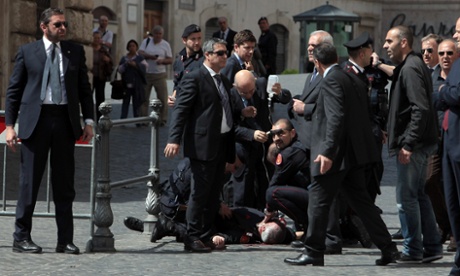 A Carabiniere police officer lies on the ground after being shot outside the Chigi Premier's office on April 28, 2013 in Rome, Italy. Two military police officers were shot in the square outside Palazzo Chigi while the new government of Enrico Letta was being sworn in.