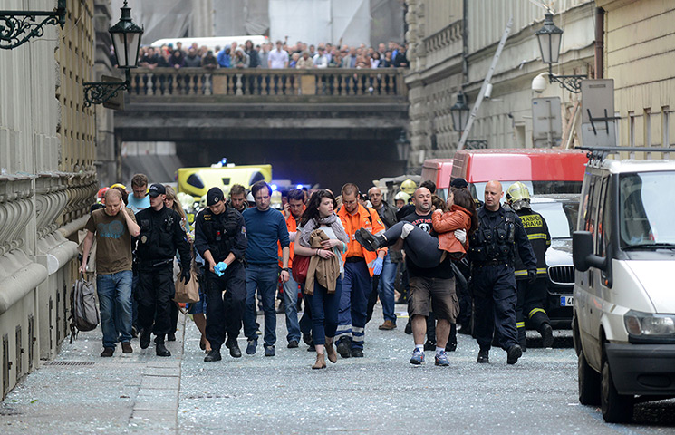 Prague explosion: Police officers, paramedics and firefighters lead injured people away 