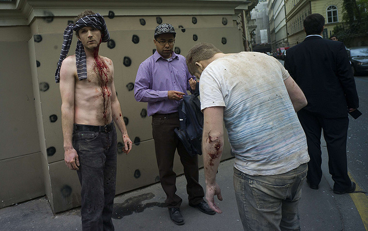 Prague explosion: Men injured by a powerful gas blast stand on the pavement