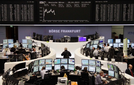 Traders work at their desks in front of the DAX board at the Frankfurt stock exchange April 29, 2013.