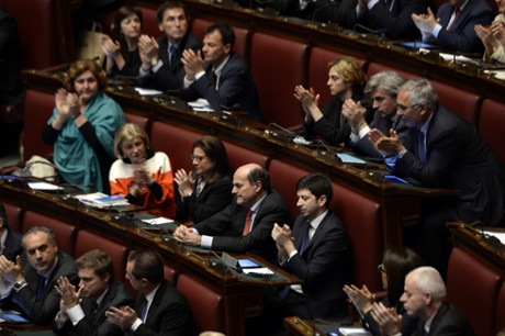 Italian deputies applaud out-going Democratic Party (PD) general secretary Pier Luigi Bersani (C - red tie) as Italy's new Prime Minister Enrico Letta delivers his speech at the Parliament in Rome on April 29, 2013.