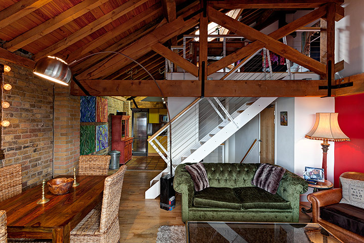 homes - attic: wooden room in attic with flooring and sofa