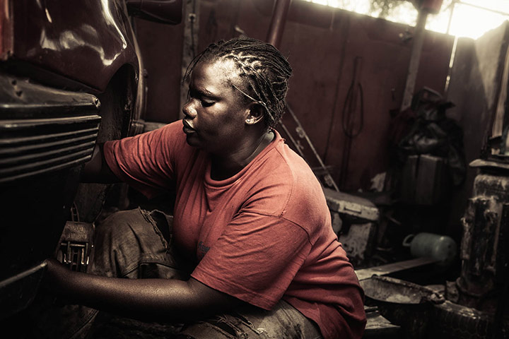 Big Picture - April 6: African woman dressed in red t-shirt sitting in garage