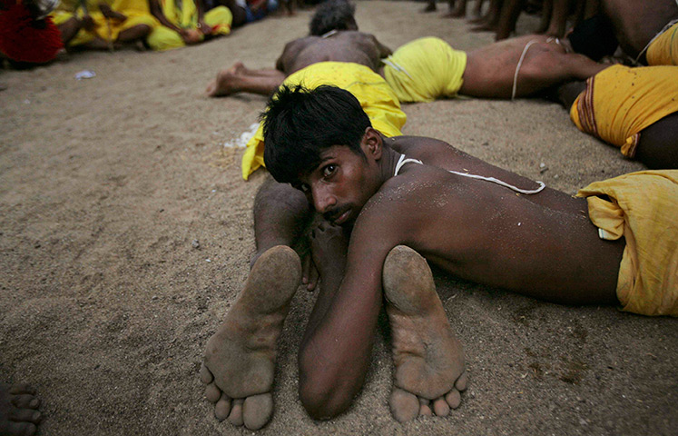 24 hours: Kulagarh, India: Devotees perform rituals of penance on hot sand during the