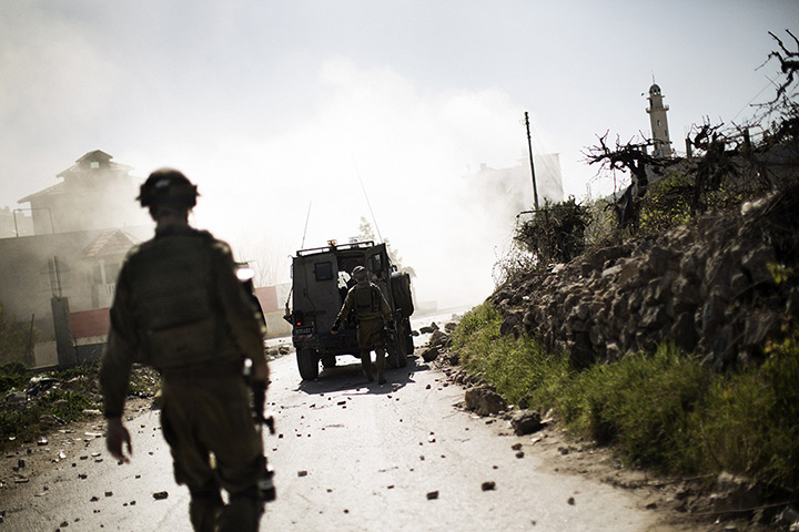 24 hours: West Bank: Israeli soldiers walk toward a cloud of tear gas during clashes 