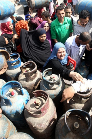 Egyptians gather to buy cooking gas cylinders at a selling depot in Cairo. Egypt increased the price of state-subsidized the cylinders as officials prepare to negotiate with the International Monetary Fund (IMF) on a much-needed 4.8-billion-dollar loan to revitalize an economy battered by political upheaval and strikes.