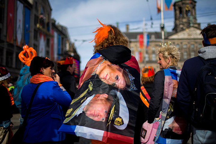 Netherlands inauguration: People wrapped in flags wait outside the Royal Palace