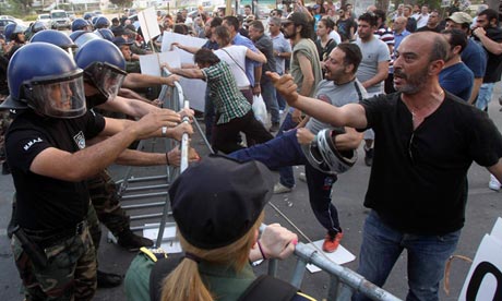 Demonstrators clash with police outside the parliament building in Nicosia