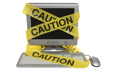 Internet privacy: Caution tape on computer