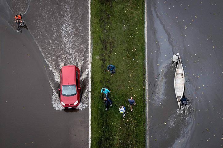 24 hours in pictures: La Plata, Argetnina: An aerial view of a boat and a car on a flooded street