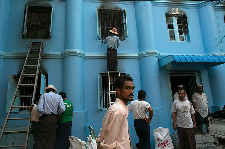 24 hours in pictures: Rangoon, Burma: Burmese workers clean a burned mosque