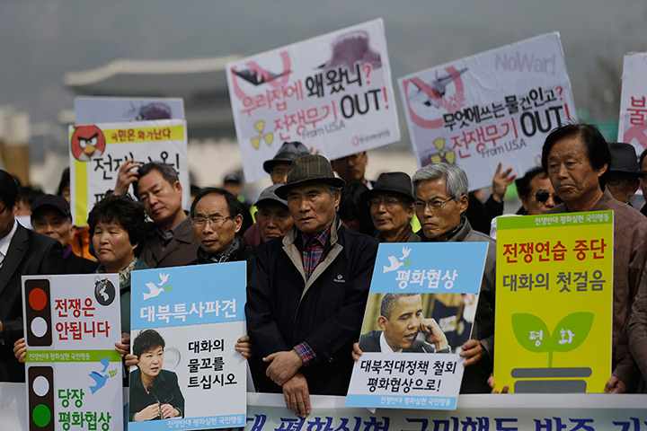 Korea tensions: Anti-war protesters hold signs during a rally 