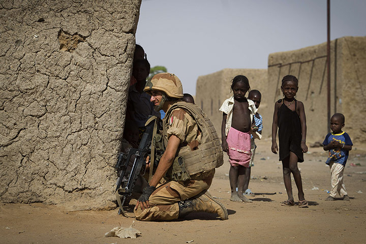 24 Hours: A French soldier keeps a lookout next to children in Gao, Mali