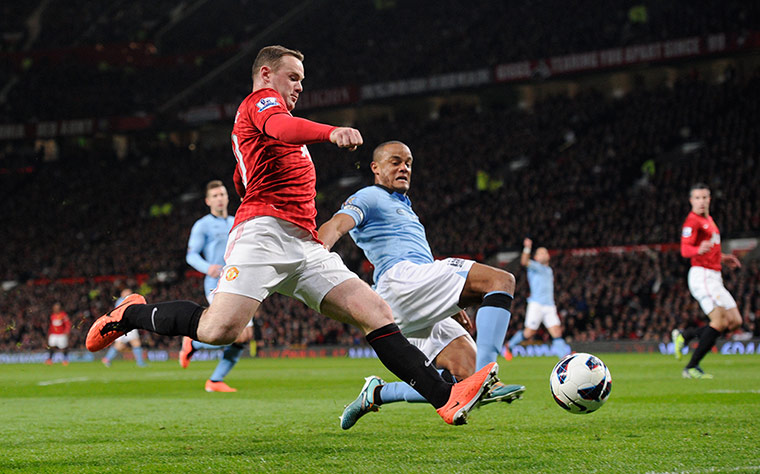 United versus City: Wayne Rooney attempts to get a cross ahead of Vincent Kompany