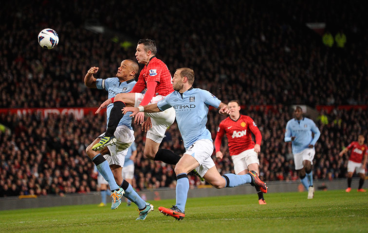 The Manchester derby: Robin van Persie leaps between Vincent Kompany and Pablo Zabaleta
