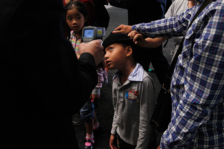 24 hours: Hong Kong, China: Security personnel takes a body temperature reading